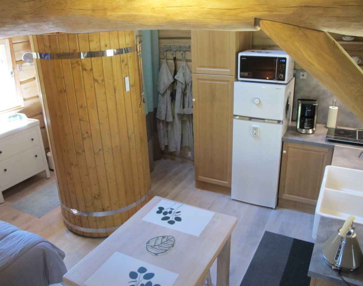 Hébergement insolite en Champagne-Ardenne, intérieur en bois avec cuisine moderne.