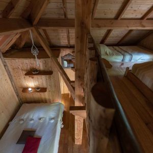 Cabane en bois chaleureuse avec lits superposés et ambiance rustique.