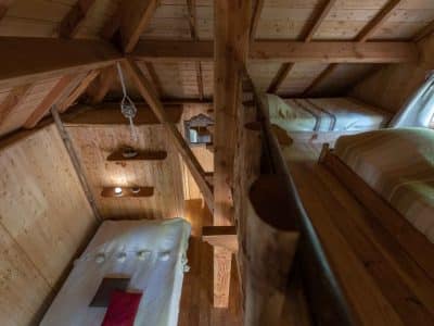Cabane en bois chaleureuse avec lits superposés et ambiance rustique.