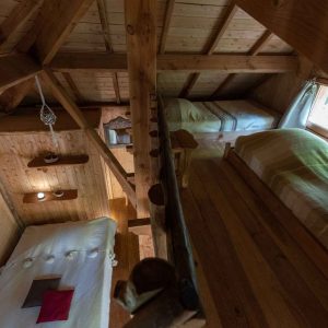 Chalet en bois avec lit douillet et vue sur la nature en Auvergne-Rhône-Alpes.