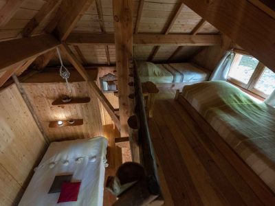 Chalet en bois avec lit douillet et vue sur la nature en Auvergne-Rhône-Alpes.