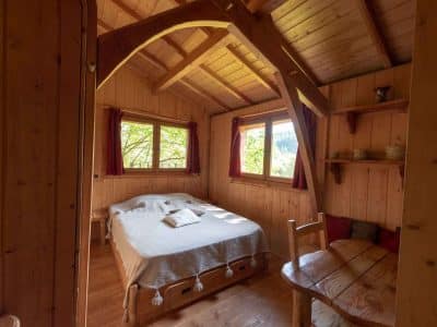 Chalet en bois chaleureux avec lit douillet et vue sur la nature.
