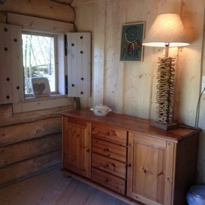 Intérieur dun chalet en bois, lumineux avec un meuble en bois et une lampe design.