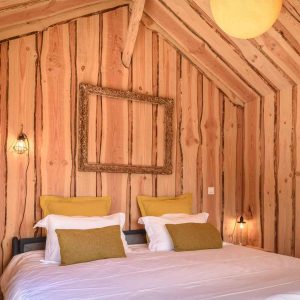 Chalet en bois chaleureux avec murs en pin et literie confortable en Aquitaine.