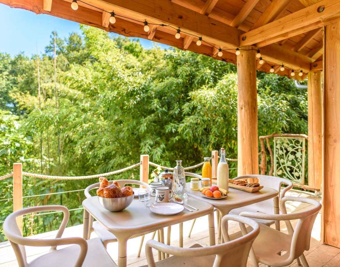 Cabane en bois en Aquitaine avec terrasse et vue sur la nature verdoyante.