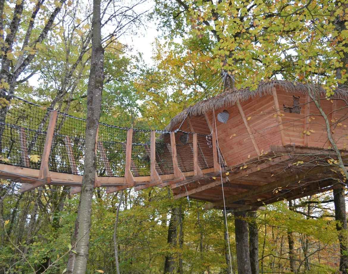Cabane perchée dans les arbres, entourée de feuillage coloré en Pays de la Loire.