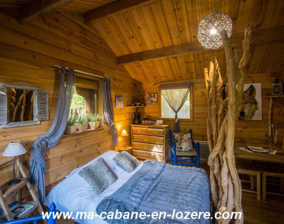 Cabane en bois dans le Languedoc-Roussillon, avec lit douillet et décor naturel.