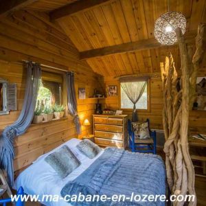 Cabane en bois dans le Languedoc-Roussillon, avec lit douillet et décor naturel.
