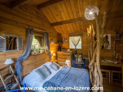 Cabane en bois dans le Languedoc-Roussillon, avec lit douillet et décor naturel.