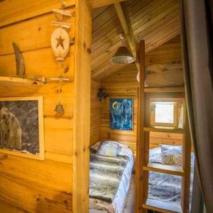 Cabane en bois dans le Languedoc-Roussillon, avec une échelle menant à un lit douillet.