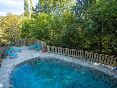 Cabane perchée en Languedoc-Roussillon avec piscine naturelle entourée darbres.