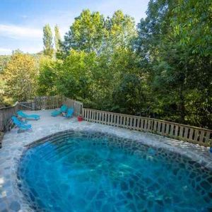 Cabane perchée en Languedoc-Roussillon avec piscine naturelle entourée de verdure.