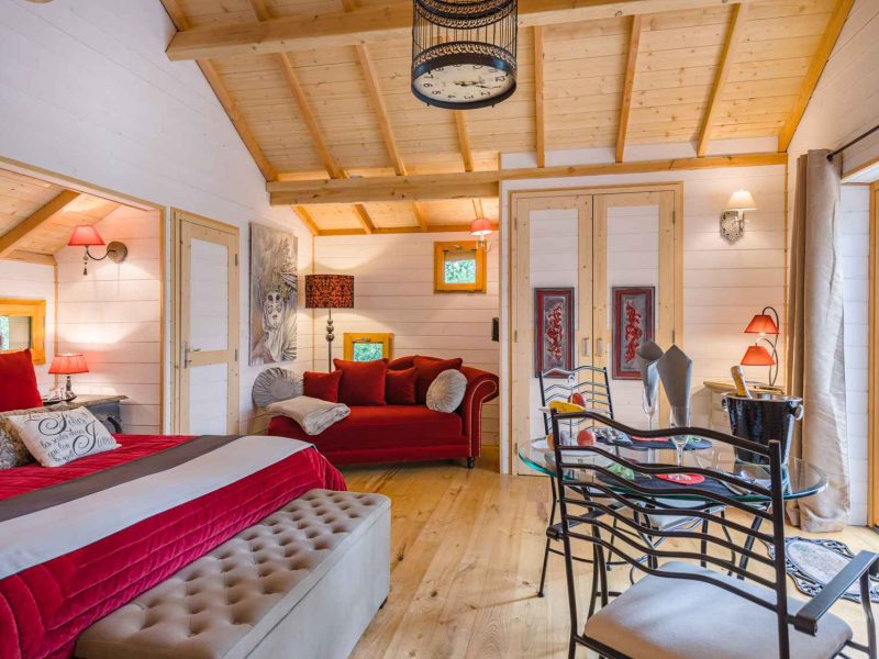 Chalet cosy avec un intérieur en bois, lit king-size et coin salon accueillant.