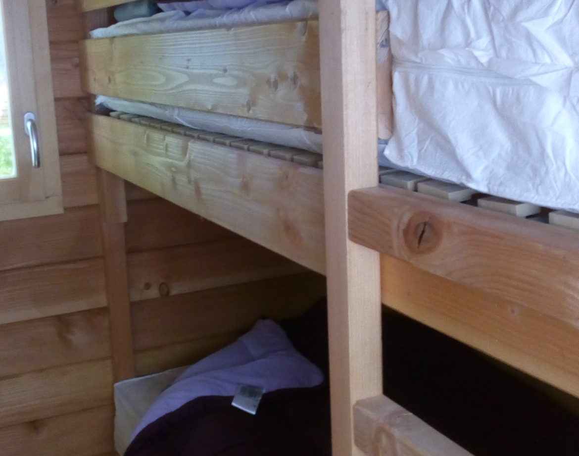 Chalet en bois avec lits superposés, ambiance chaleureuse et naturelle.
