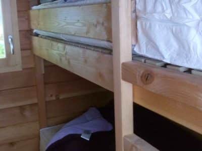 Chalet en bois avec lits superposés, ambiance chaleureuse et naturelle.