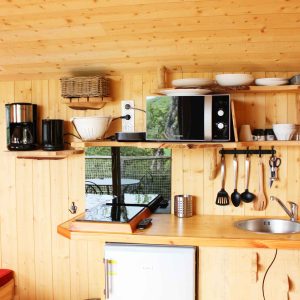 Cabane en bois avec cuisine équipée et décoration chaleureuse en Auvergne-Rhône-Alpes.