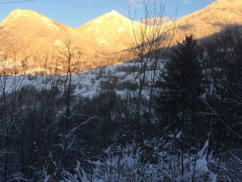 Chalet en montagne, entouré de neige et de paysages enneigés majestueux.