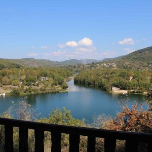 Cabane perchée avec vue panoramique sur la rivière et les collines verdoyantes.