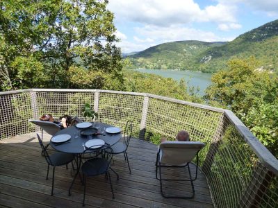 Cabane perchée avec vue panoramique sur le lac et la nature environnante.