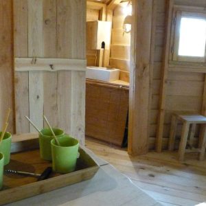 Hébergement insolite en bois avec cuisine équipée et ambiance chaleureuse.
