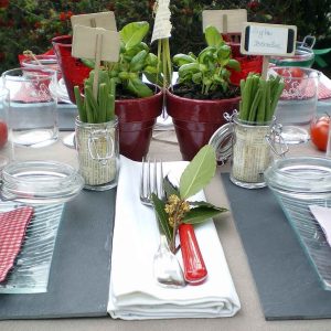 Table élégamment dressée avec des pots de plantes et des tomates cerises, hébergement insolite.