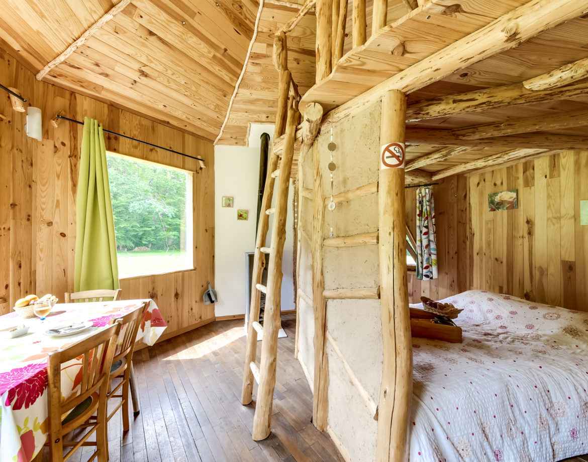 Cabane en bois dans le Grand-Est, avec un lit douillet et une décoration naturelle.
