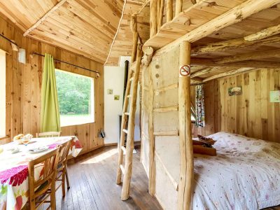 Cabane en bois dans le Grand-Est, avec un lit douillet et une décoration naturelle.