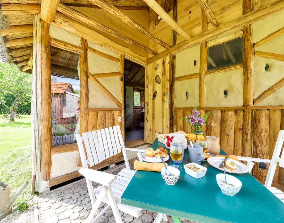 Hébergement insolite en bois à Grand-Est, avec une terrasse accueillante et décorée.