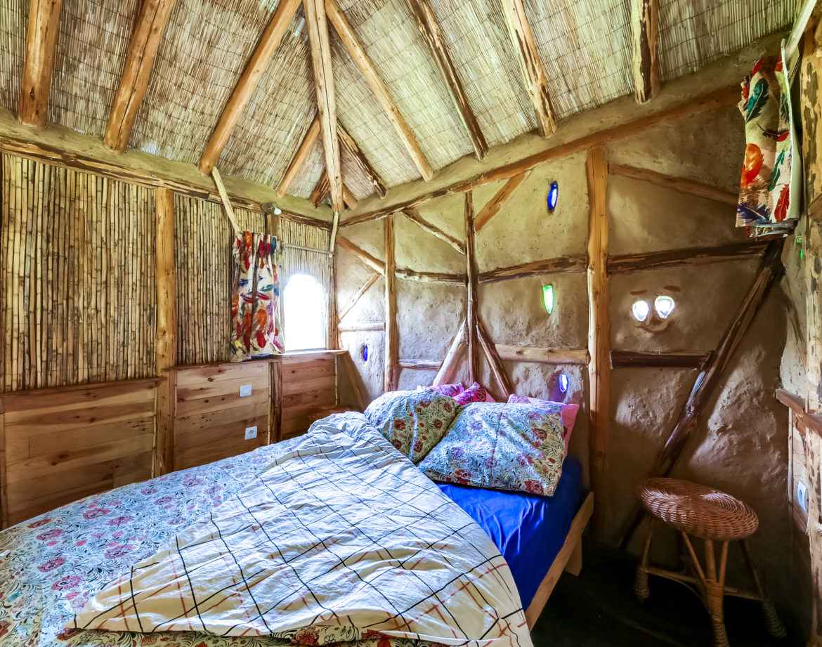 Chalet en bois au Grand-Est, intérieur chaleureux avec lit douillet et décor coloré.