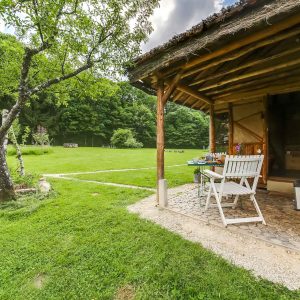 Cabane en bois à Grand-Est, avec terrasse et jardin verdoyant.