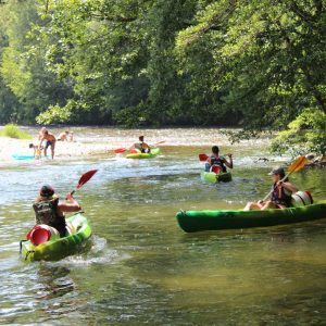 Hébergement insolite en Languedoc-Roussillon, avec canoës sur une rivière paisible.