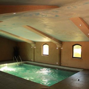 Hébergement insolite en Auvergne-Rhône-Alpes avec piscine intérieure et murs en pierre.