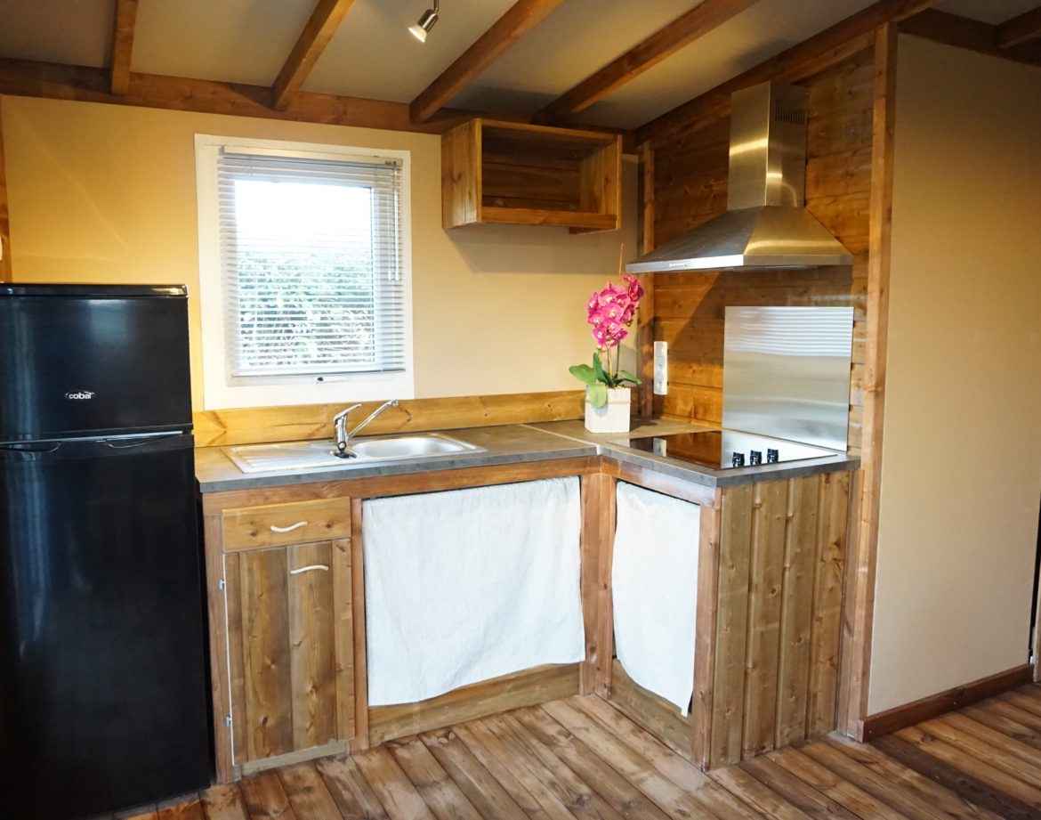 Hébergement insolite en bois avec cuisine équipée et décoration chaleureuse.