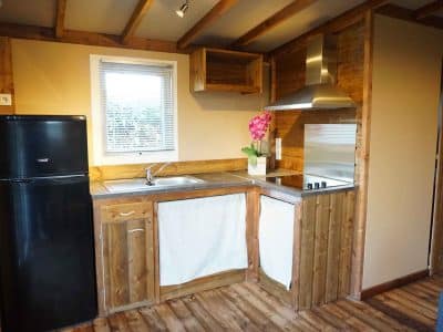 Hébergement insolite en bois avec cuisine équipée et décoration chaleureuse.