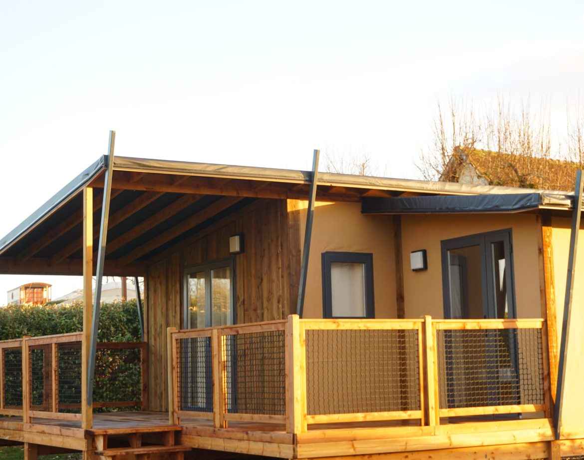 Cabane en bois avec terrasse, située dans un cadre naturel apaisant.