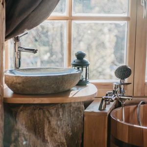 Hébergement insolite en Provence-Alpes-Côte dAzur avec lavabo en pierre et baignoire en bois.