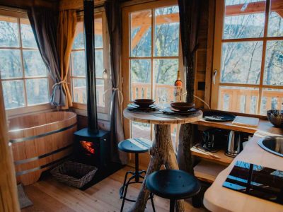 Cabane en bois avec poêle à bois et vue sur la nature, idéale pour un séjour romantique.