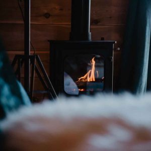 Chalet en bois avec poêle à bois, offrant une ambiance chaleureuse et cosy.