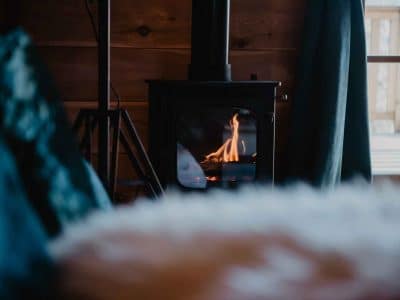 Chalet en bois avec poêle à bois, offrant une ambiance chaleureuse et cosy.