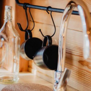 Hébergement insolite en Provence-Alpes-Côte dAzur avec cuisine en bois et tasses suspendues.