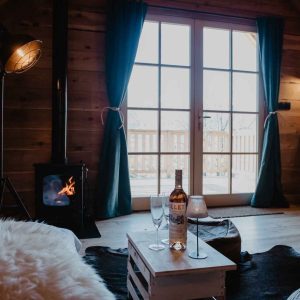 Chalet en bois avec poêle à bois, vue sur la nature et ambiance cosy.