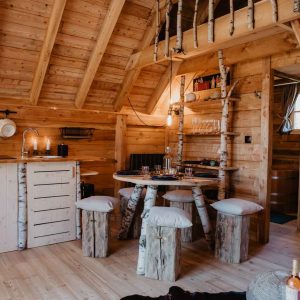 Cabane en bois cosy avec mobilier en troncs darbres, ambiance chaleureuse.