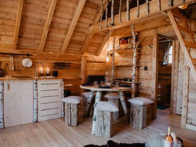 Cabane en bois cosy avec mobilier en troncs darbres, ambiance chaleureuse.