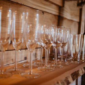 Verres élégants alignés sur une étagère en bois dans un hébergement insolite en Provence.
