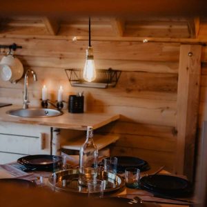 Cabane en bois en Provence-Alpes-Côte dAzur, avec une table dressée et une lumière chaleureuse.