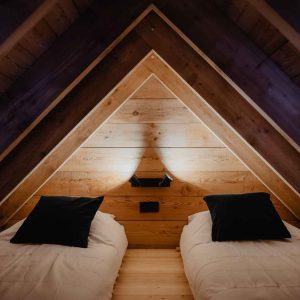 Chalet en bois avec lits jumeaux, ambiance chaleureuse et design moderne.