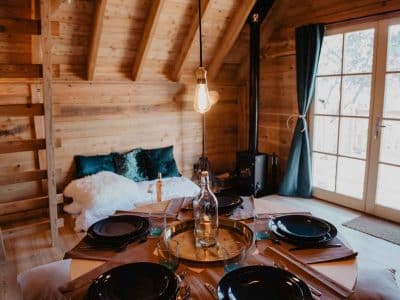 Cabane en bois chaleureuse avec table élégante et lumière suspendue.