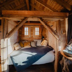 Cabane en bois avec lit douillet et vue sur la nature en Provence-Alpes-Côte dAzur.