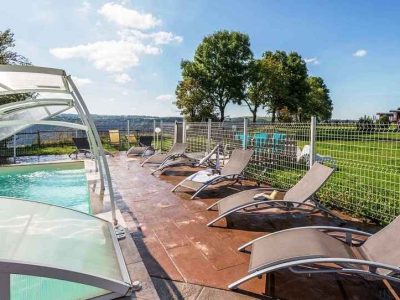 Hébergement insolite en Auvergne avec piscine et chaises longues ensoleillées.