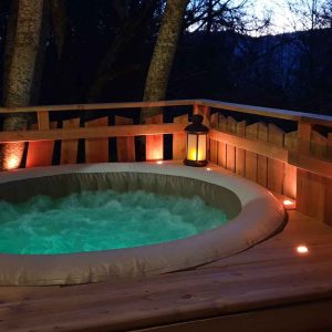 Hébergement insolite en cabane avec jacuzzi extérieur, ambiance chaleureuse et romantique.